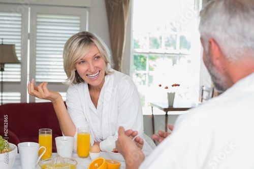 Cheerful woman having breakfast with cropped man