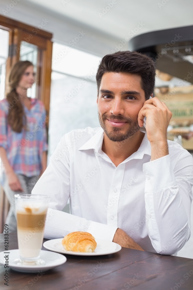Smiling man using mobile phone in coffee shop Smiling man using mobile phone in coffee shop