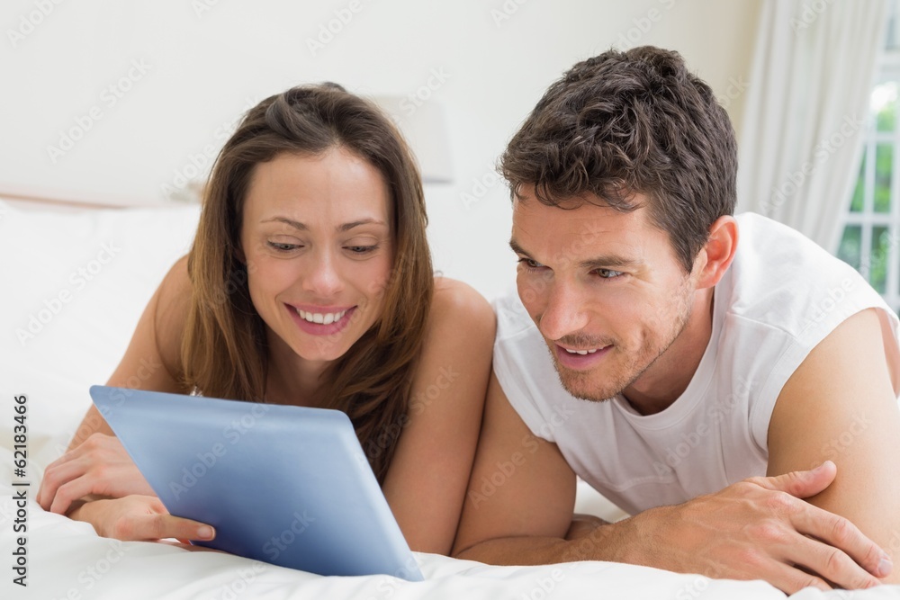 Couple using digital tablet in bed Couple using digital tablet in bed