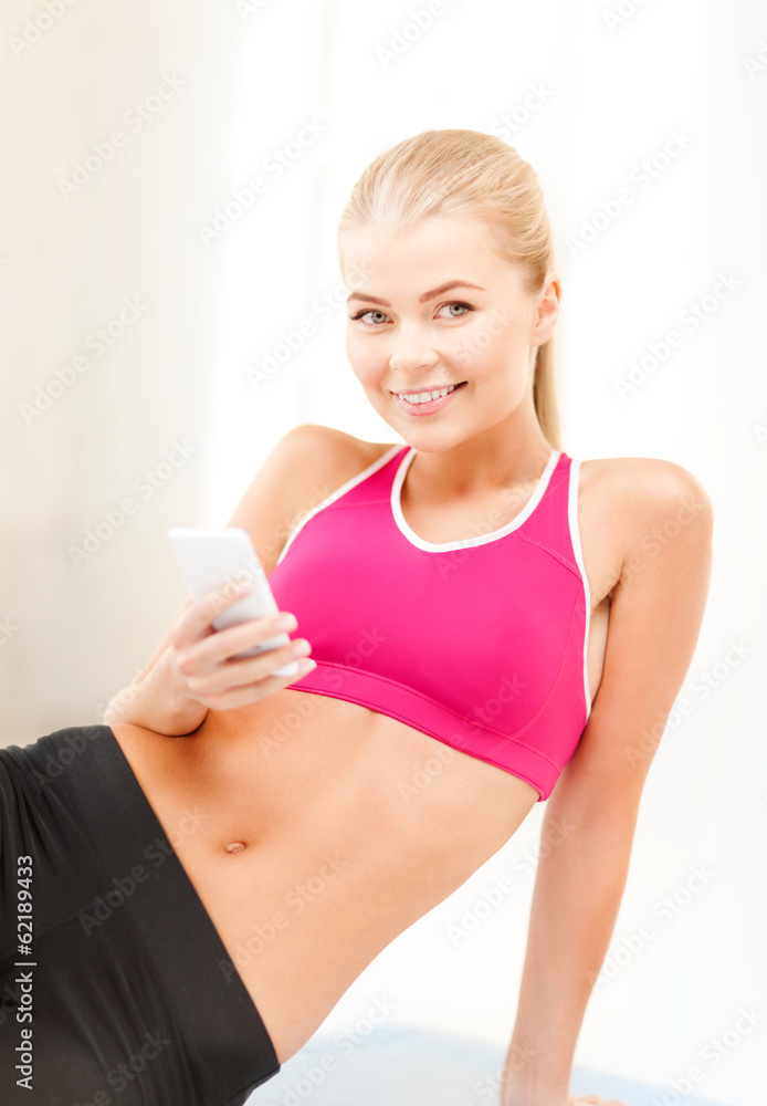 smiling woman sitting on the floor with smartphone smiling woman sitting on the floor with smartphone