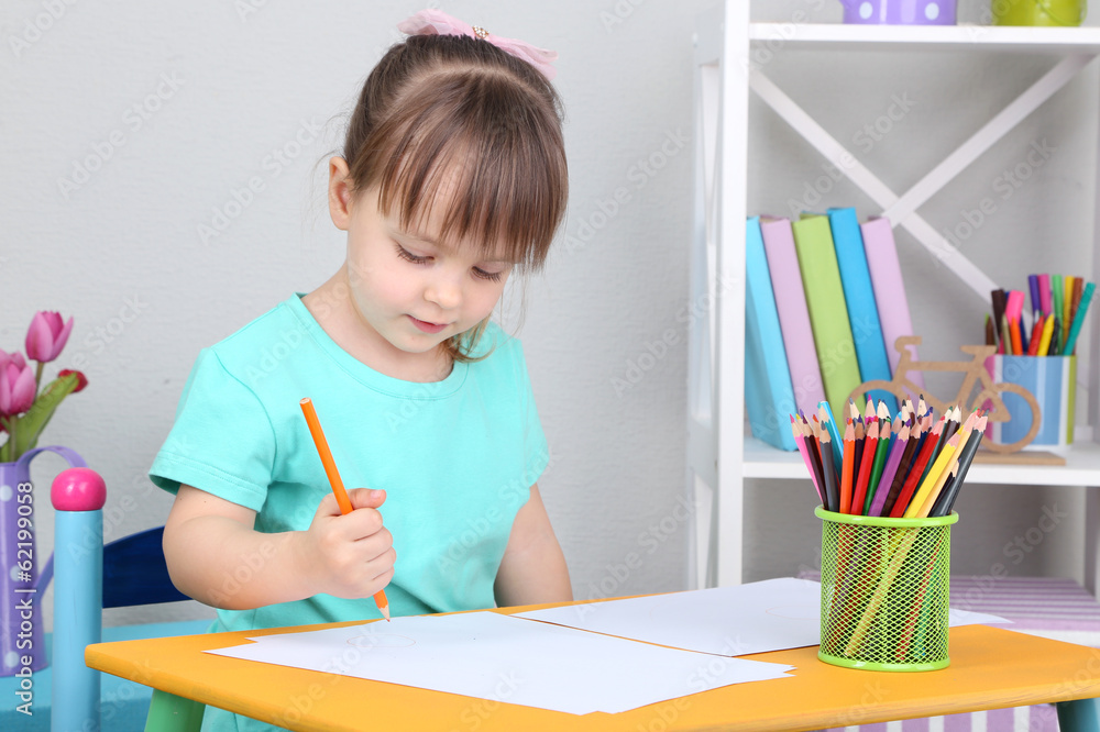 Little girl draws sitting at table in room Little girl draws sitting at table in room