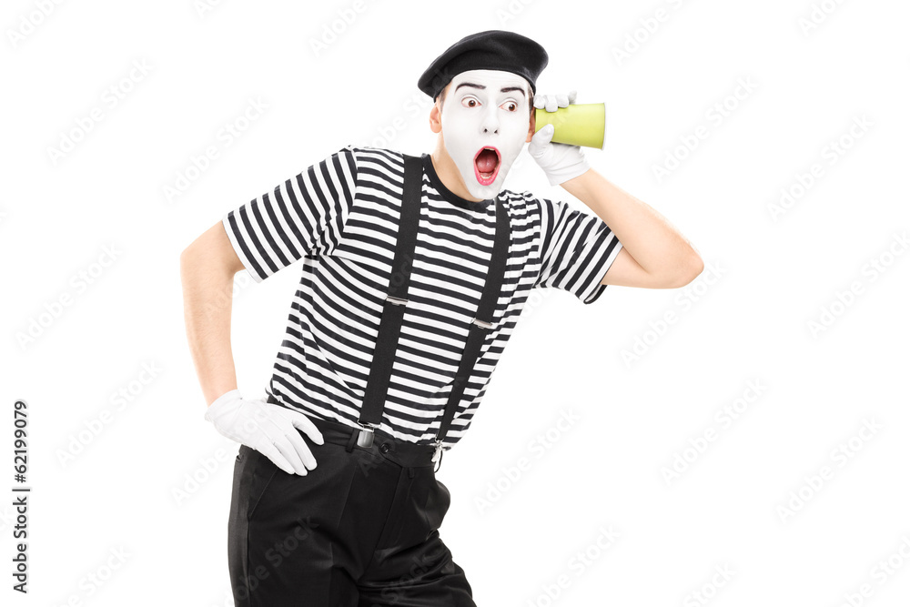 Male mime artist listening through wall with a cup