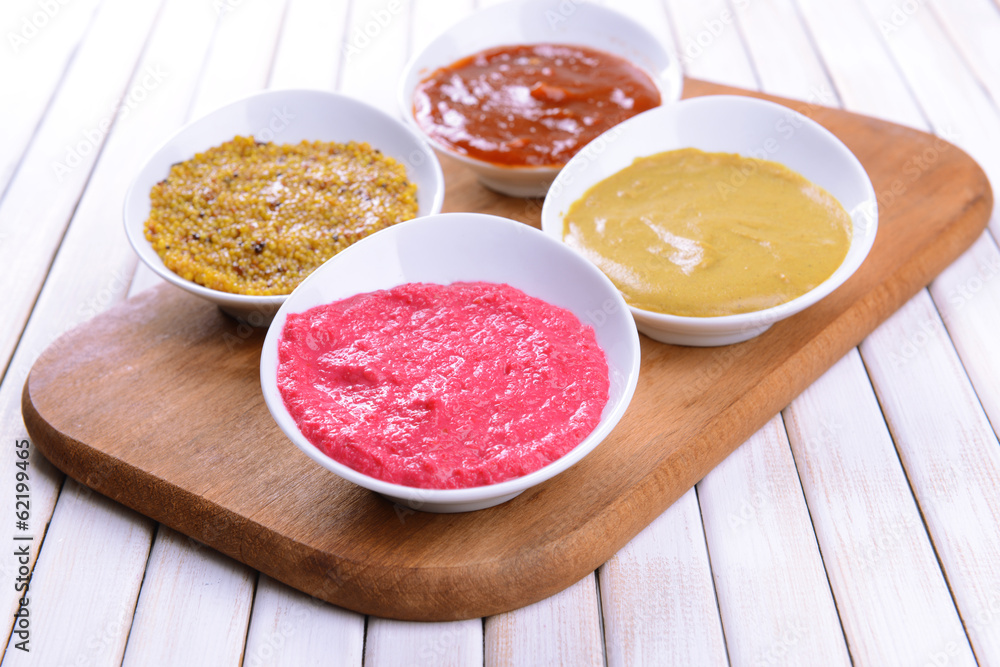 Various sauces on chopping board on table close-up