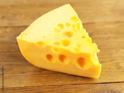 Piece of cheese on wooden background