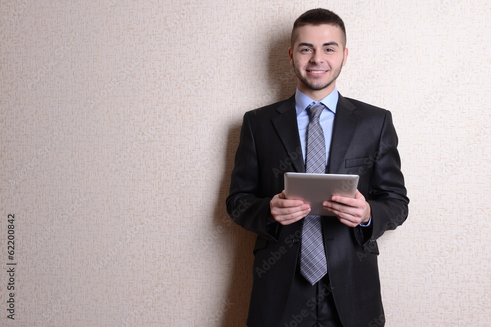 Portrait of businessman with tablet near wall Portrait of businessman with tablet near wall