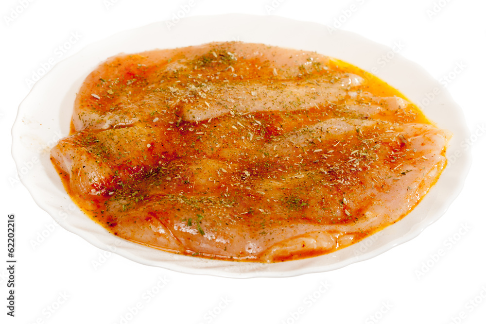 Raw marinated chicken breasts with spices isolated on white