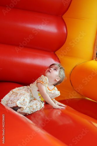 Little happy girl lies in bouncy castle