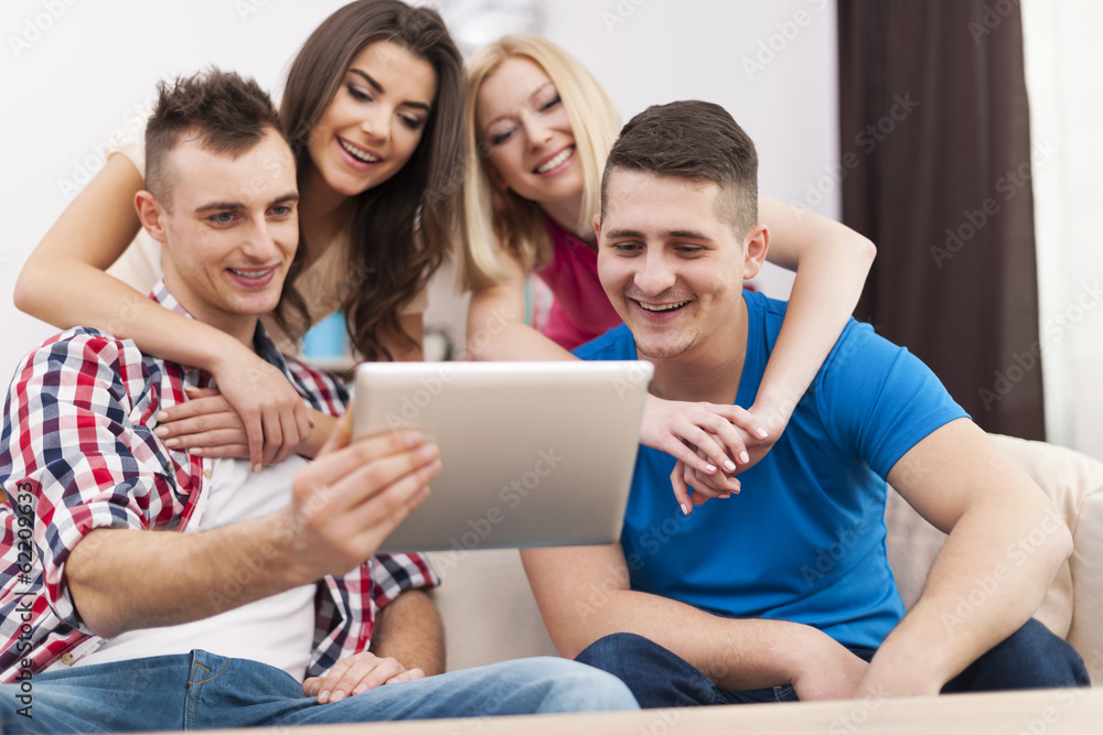 Happy friends spending free time and using digital tablet Happy friends spending free time and using digital tablet