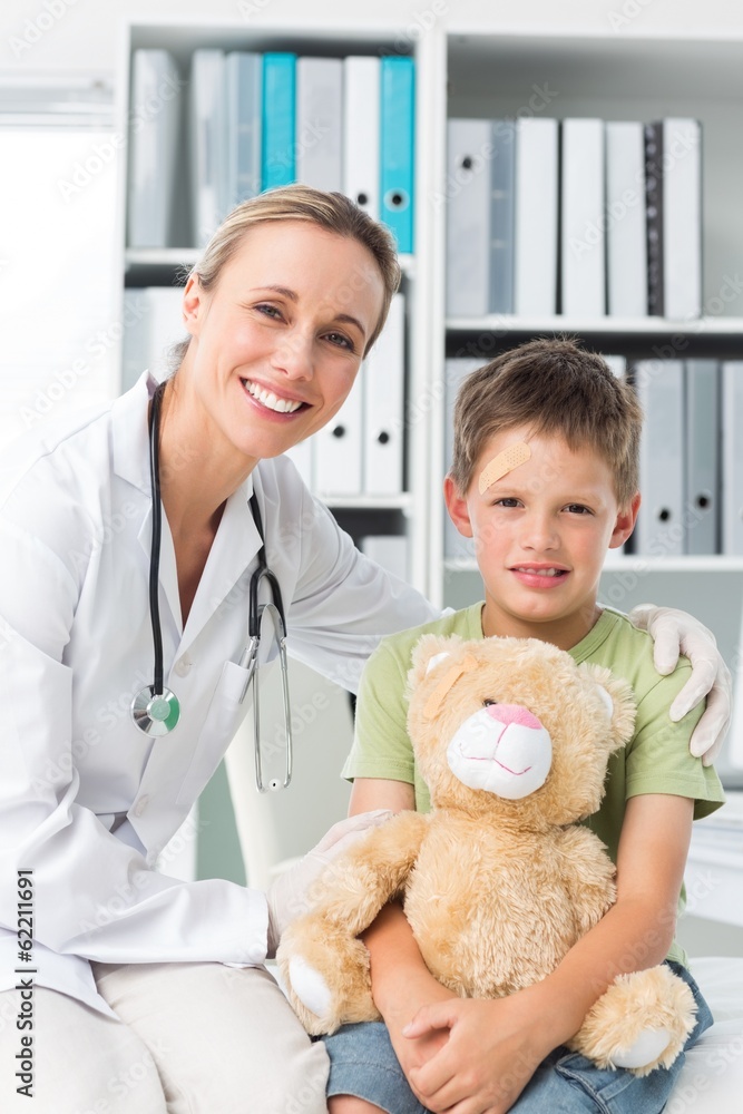 Friendly doctor with boy holding teddy bear Friendly doctor with boy holding teddy bear