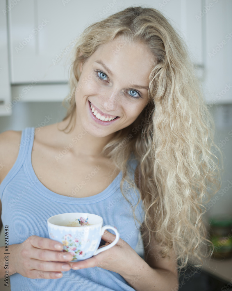 Portrait of happy woman holding tea cup in house Portrait of happy woman holding tea cup in house