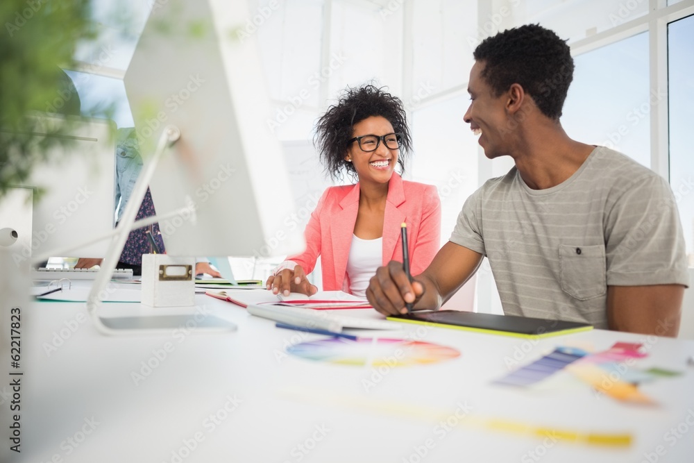 Happy casual photo editors using graphics tablet Happy casual photo editors using graphics tablet