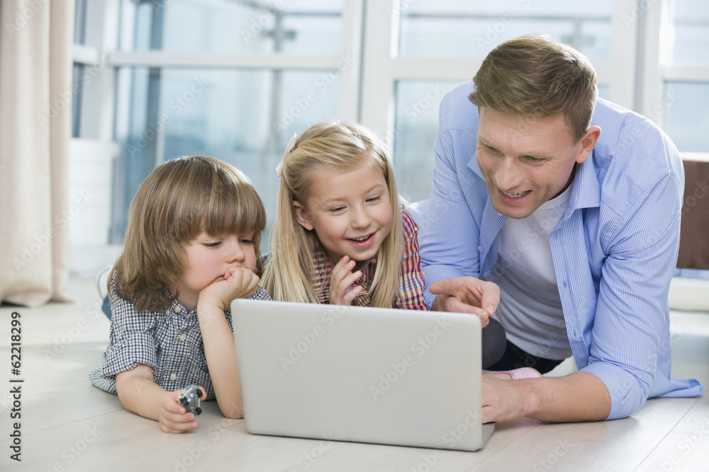 Happy father showing something to children on laptop at home Happy father showing something to children on laptop at home