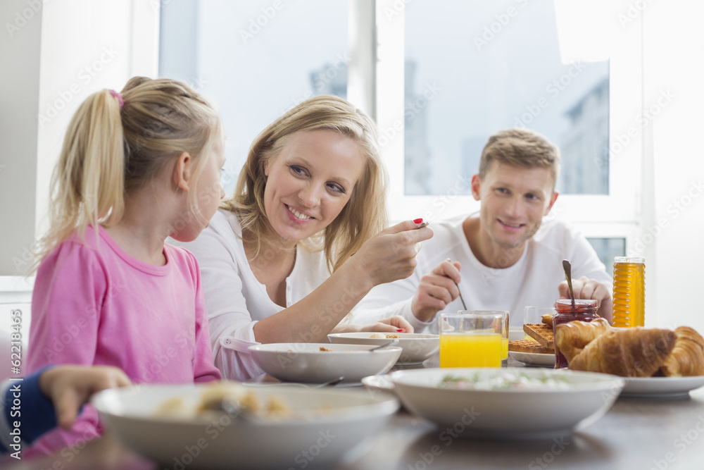 Happy family with children having breakfast at table Happy family with children having breakfast at table