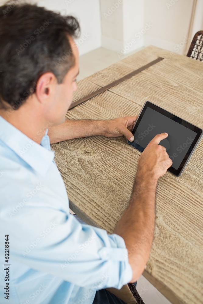 Concentrated man using digital table at home Concentrated man using digital table at home