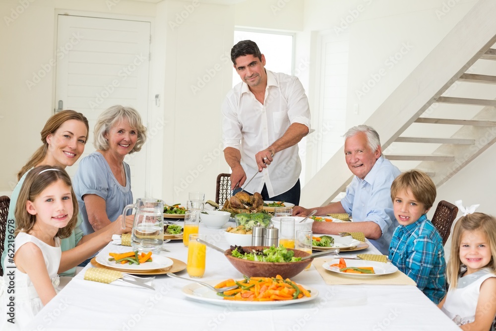 Smiling father serving meal to family
