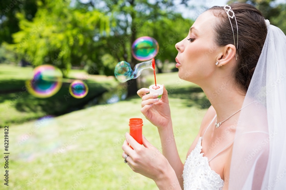 Beautiful bride blowing bubbles in garden Beautiful bride blowing bubbles in garden