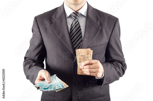 A businessman in a suit giving brazilian money