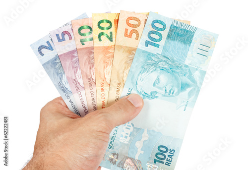 male hand holding all brazilian reais notes, brazil money