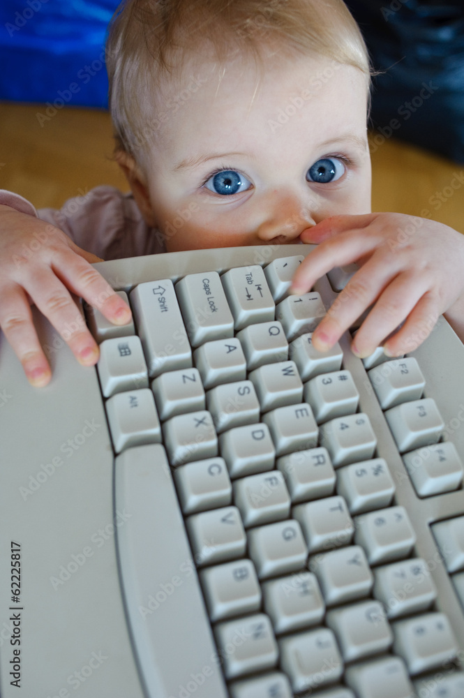 child trying to reach the computer keyboard child trying to reach the computer keyboard