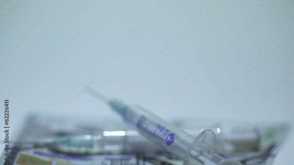 Medical syringes on money in rotation Medical syringes on money in rotation