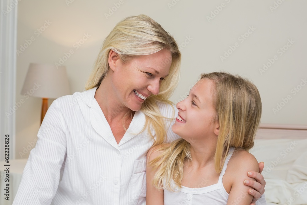 Mother and daughter looking at each other in bedroom Mother and daughter looking at each other in bedroom