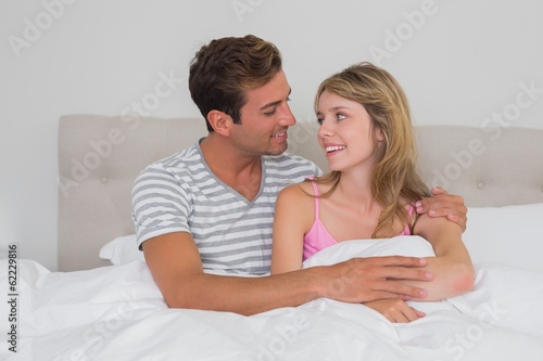 Happy relaxed couple sitting in bed