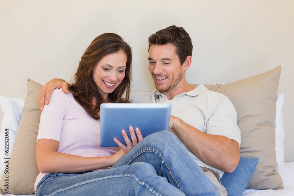 Relaxed couple using digital tablet in living room Relaxed couple using digital tablet in living room