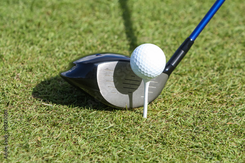 Golf ball and club in grass