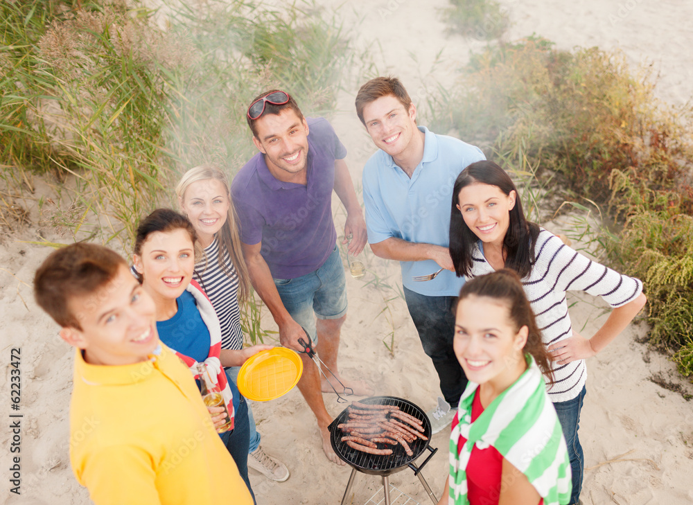 group of friends making barbecue on the beach group of friends making barbecue on the beach