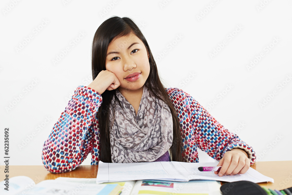 young schoolgirl sitting at her desk an look at the camera young schoolgirl sitting at her desk an look at the camera