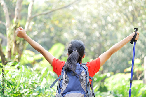 cheering woman hiker in tropical jungle