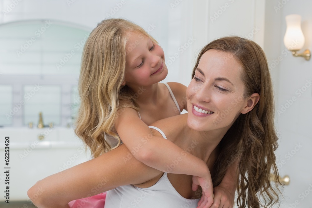 Happy woman carrying girl in house