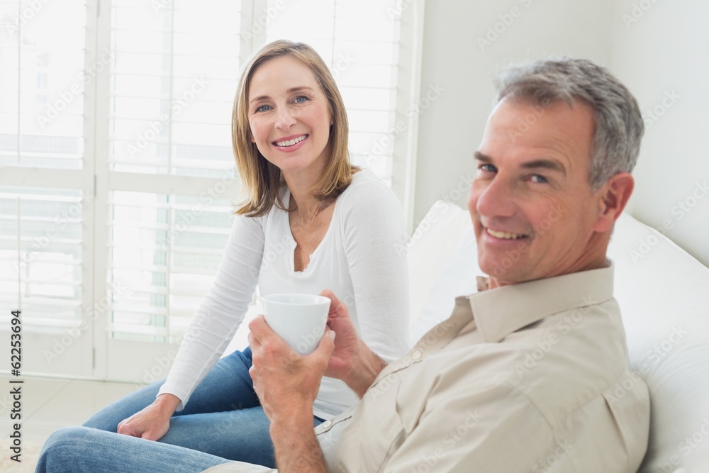 Relaxed couple with coffee cup in living room Relaxed couple with coffee cup in living room