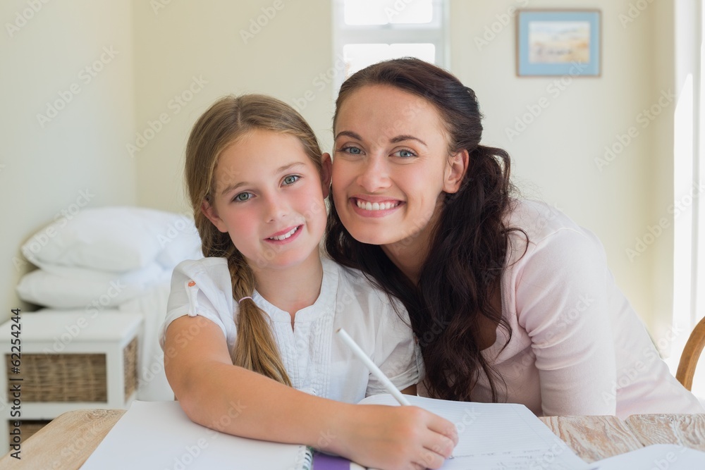 Loving mother with daughter studying at table Loving mother with daughter studying at table