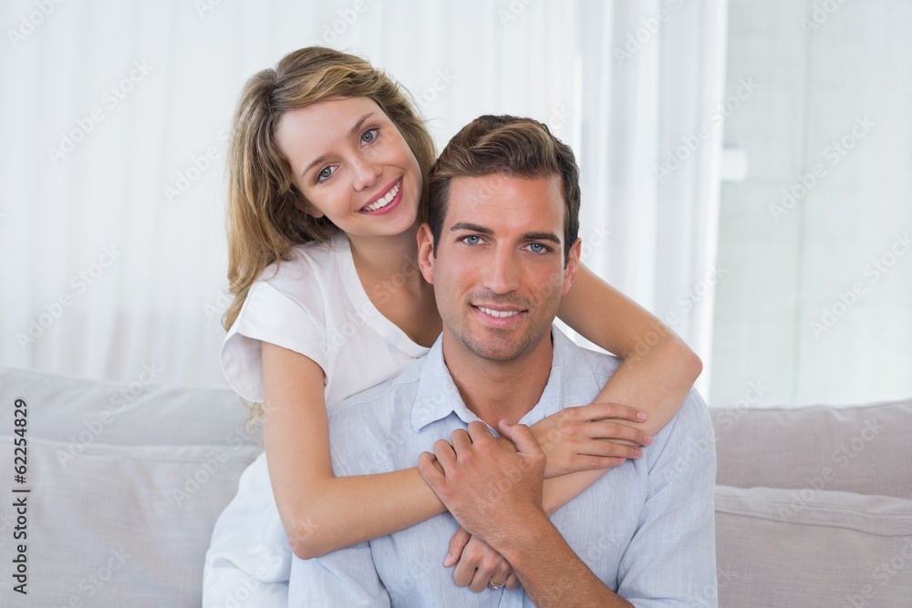 Loving young woman embracing man at home