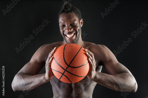 Portrait of smiling young black man shirtless with basket ball a © pio3