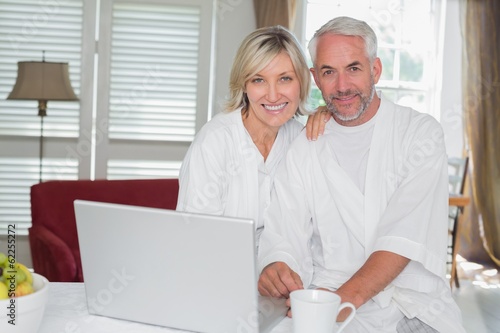 Relaxed mature couple with laptop at home