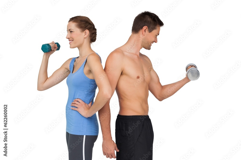 Fit young couple exercising with dumbbells Fit young couple exercising with dumbbells