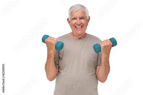 Portrait of a happy senior man exercising with dumbbells