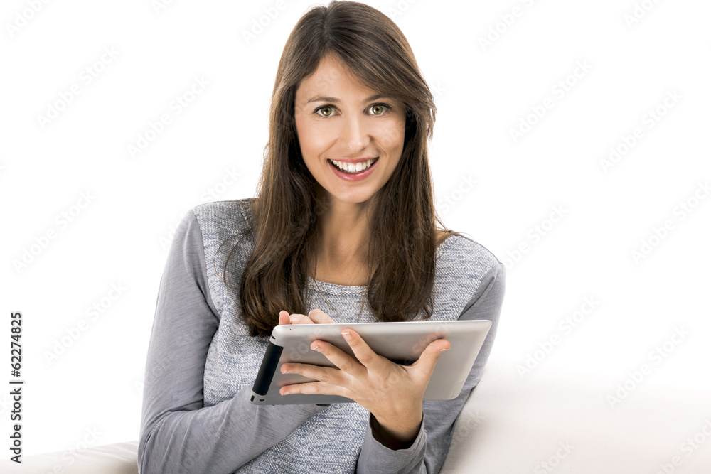 Beautiful woman sitting on the soda and working with a tablet Beautiful woman sitting on the soda and working with a tablet