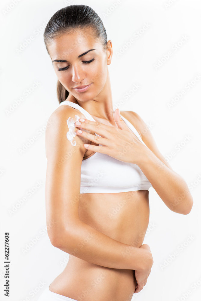 Beautiful young woman applying body lotion. Beautiful young woman applying body lotion.