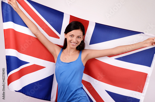 Beautiful British girl smiling holding up the UK flag.