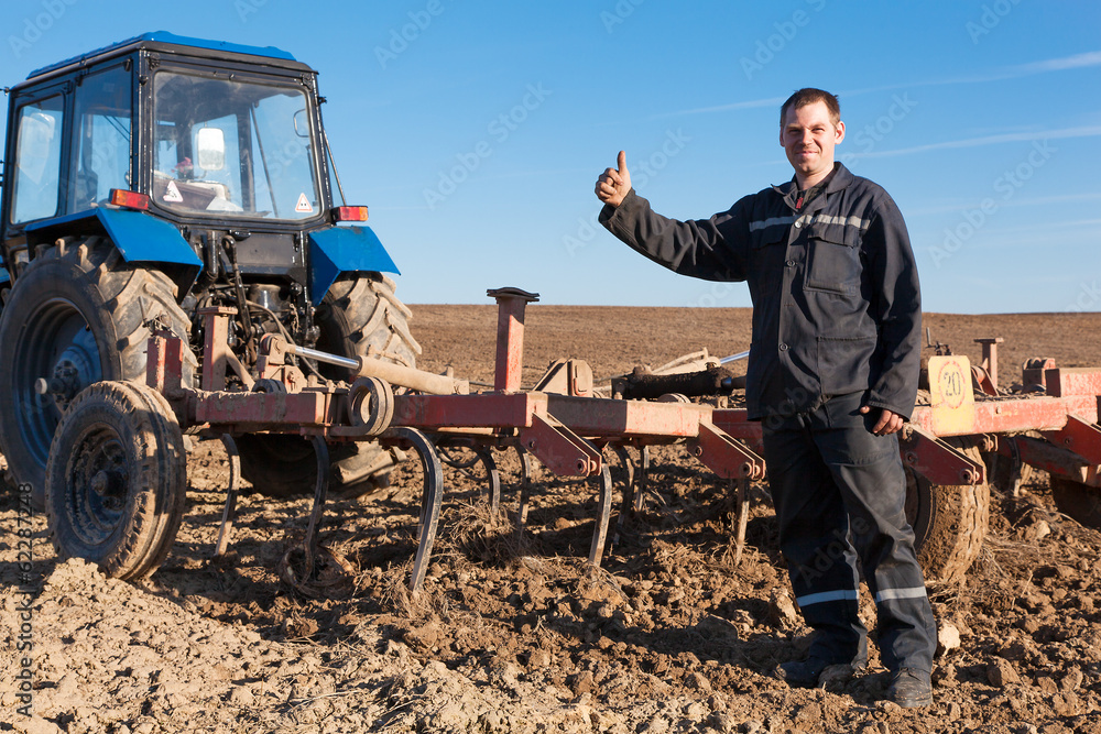 Obraz premium Farmer man standing in cultivated field and showing OK gesture
