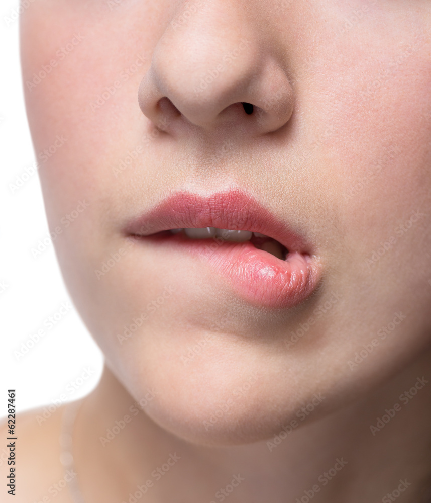 Obraz premium Young woman bites her lips closeup.