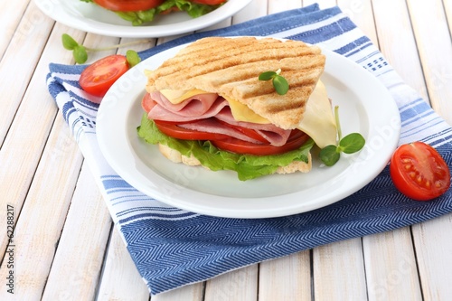 Tasty sandwich with ham on wooden table