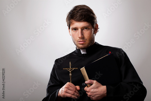 Priest with cross and holy bible