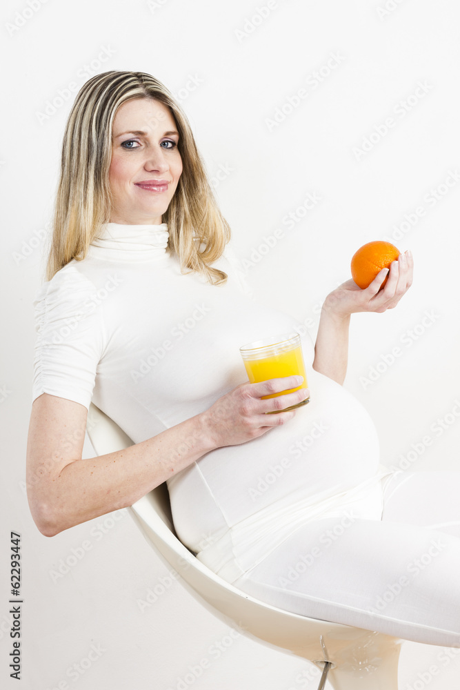 portrait of pregnant woman with a glass of orange juice and an o portrait of pregnant woman with a glass of orange juice and an o