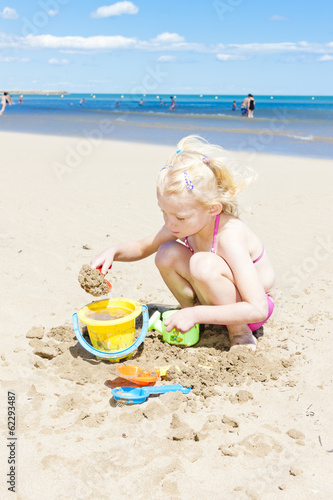 little girl playing on the beach at sea