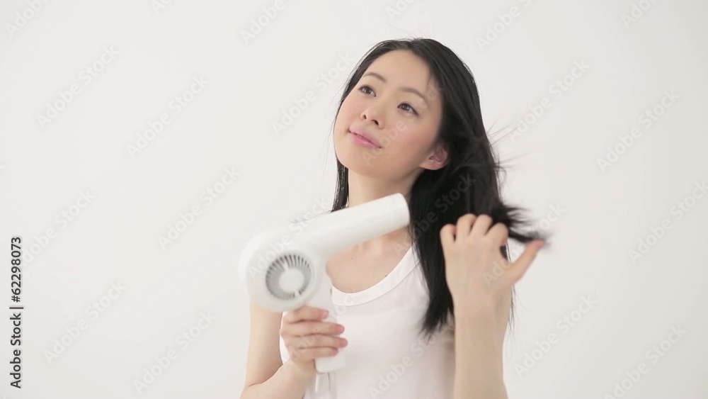 ドライヤーで髪を乾かす女性 ドライヤーで髪を乾かす女性