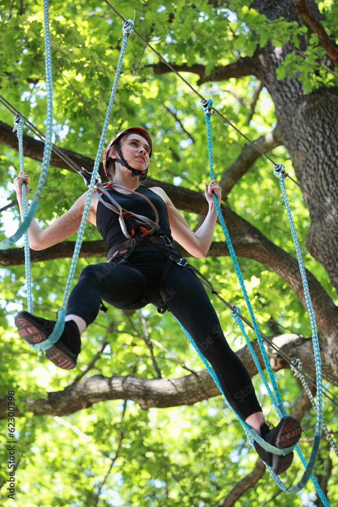 attractive woman climbing in adventure rope park